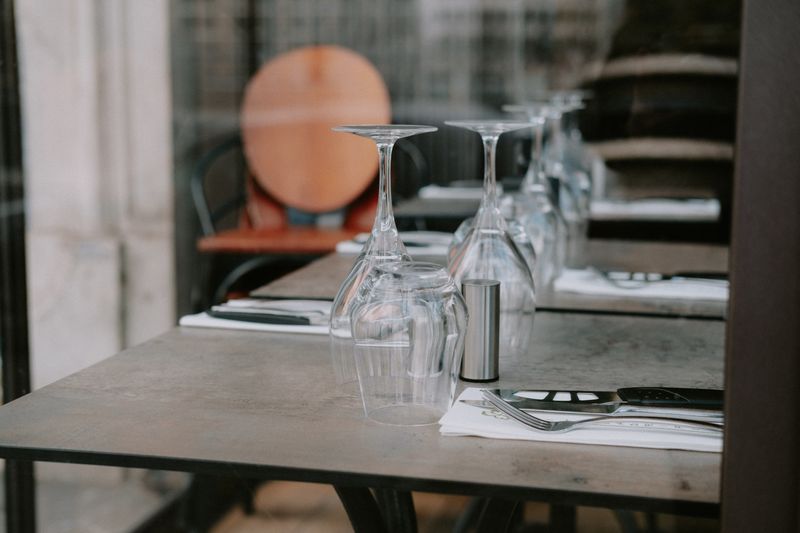 Stylish restaurant table setting with upside down glasses and cutlery on a napkin.