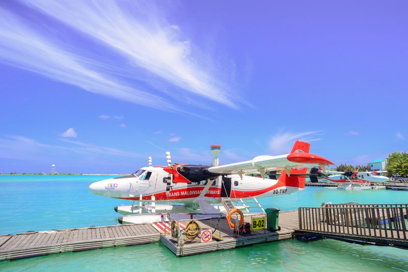 Vibrant seaplane at Maldives dock under clear skies, perfect for dream vacations.