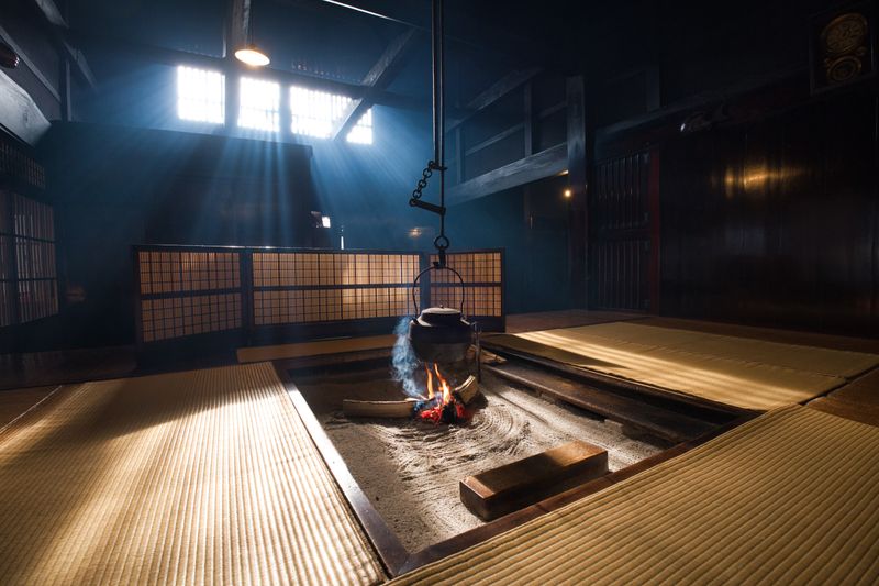 A serene Japanese tatami room with sunlight streaming in and a traditional fire pit.