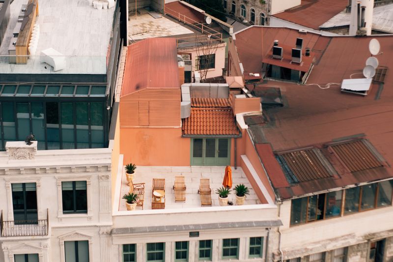 Aerial view of a cozy urban rooftop terrace with seating and plants.