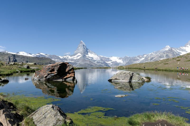 Breathtaking summer landscape of the Matterhorn reflecting in a serene alpine lake near Zermatt.