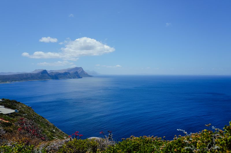 A stunning view of Cape Peninsula's coastline with clear blue water under a vibrant sky.